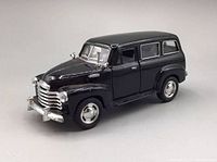Front and driver side angle of black 1950 Chevy Suburban Kinsmart diecast model car showing front chrome grille, bumper, side mirror, and tires.