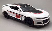 White and red Chevrolet Camaro ZL1 diecast model car side-angle view showing front wheel detail and racing decals.