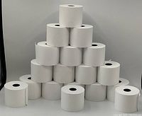 Eighteen white cash register tape rolls stacked in a pyramid.