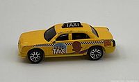 Side view of yellow Matchbox Little Bill taxi cab diecast car showing cartoon character and taxi details.