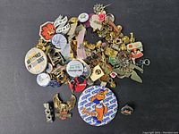 Overview photo of a large assortment of pins, including promotional, novelty, and decorative pins showing varied designs and colors.