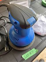 Side angle showing blue and black compact polisher with power cord and ventilation slots.