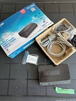 TP-LINK TD-8816 modem router with original box and accessories shown on table including cables, ADSL splitter, and power adapter.