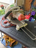 Side view of the 10 inch Ridgid mitre saw showing motor housing, handle, and table base with measurement markings.