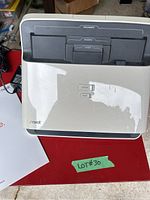 Neat desktop document scanner with visible slots on top panel and signs of wear on top surface.