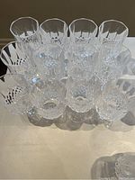 Top view showing 12 crystal wine glasses arranged closely, highlighting the intricate cut details on the bowls.
