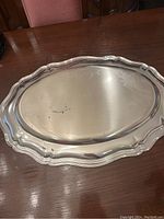 Top side of the silver plated serving tray showing surface wear and decorative border