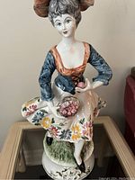 Front view of the Capodimonte porcelain girl statue showing dress detail and facial features.