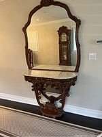 Full view of the console table with marble top and attached ornate mirror showing the overall style and dimensions.
