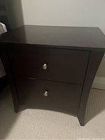 Front view of wood side table with two drawers, espresso stain finish and silver knobs.