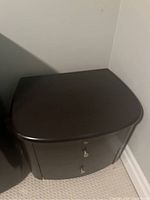 Angled view of the espresso stain end table showing top surface and drawer front.