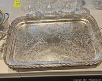 Top view of rectangular silver plated tray showing ornate floral and scroll engraved pattern on the surface and beaded edge.