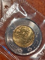 Front obverse side of 2015 John A MacDonald Canadian two dollar commemorative coin in protective plastic.