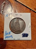 Front angled view of the 1844 Bank of Montreal Half Penny token in white holder, showing detail of intricate design and protective casing.