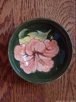 Top-down view of the bowl showing pink flower and green leaf design inside.