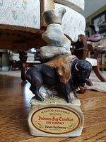 Front view of porcelain buffalo decanter with detailed buffalo figure and Manitoba Centennial label for Hudson's Bay Canadian Rye Whiskey.