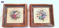 Two framed petit point floral embroideries side by side on white background.