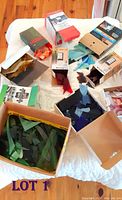 Multiple boxes containing stained glass off cuts of various colors including green, blue, teal, pink, red, purple, and clear with some pieces textured or smooth.