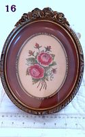 Front view of the petit point rose embroidery in the ornate oval wooden frame, showing the full piece with scale.