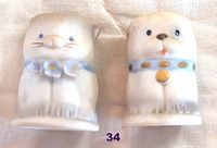 Photo showing both vintage bisque thimbles shaped as a kitten and a puppy, highlighting their hand-painted details and overall condition.