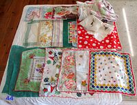 Full collection of folded and laid out vintage handkerchiefs showing various floral and colorful designs on cloth, mostly about 11 inches square.