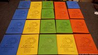 Top view of 20 hardcover books with colorful covers arranged on a cloth surface. Titles 'Collection a la Decouverte' and different subtitles in French are visible on each book.