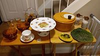 Full view of all items on tables showing variety of kitchen and decorative household pieces with autumn fall colours theme