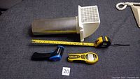 Full lot image showing four items including the Straight Line sonic meter, Mastercraft laser thermometer, washroom vent with grill, and tape measure extended on a dark carpet.