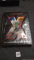 Front view of the sealed book showing the full cover with X-Men logo and character collage in the 'X'.
