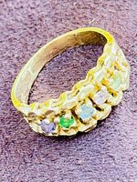 Oblique view of ring face showing scalloped gallery and five colored gemstones.