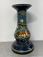 Front view of the dark blue ceramic plant stand with floral hand painting.