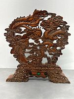 Front view of the hand-carved natural boxwood dragon sculpture showing detailed dragon and cloud motifs with green stone accents on base.