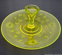 Top-down view of the yellow uranium glass tidbit tray showing the etched floral design and triangular handle.