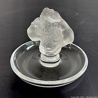 Top/front view of frosted glass mermaid figures on clear glass circular base, showing detail.