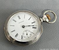 Front view: white enamel dial, Roman numerals, blued steel hands, subsidiary seconds