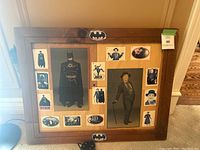 Wooden framed collage of Batman and Joker cards and images, including a large Batman image center-left and a large Joker image center-right with smaller cards around the frame.