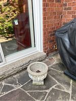 First image showing one cement planter near sliding glass door outside.