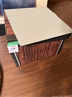 Gray LEGO baseplate with moon surface design resting on box.