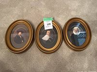 Three oval frames displayed together, each containing a portrait print with gold-tone borders and black mats.