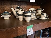 Full set of Royal Doulton china pieces arranged on a wooden shelf.