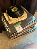 Stack of vinyl records with ABBA Greatest Hits on top and vinyl singles stacked on top of that.