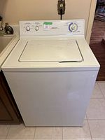 Front view of the washer with lid closed showing control panel and exterior condition