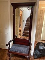 Front view of wooden hall chair with large attached mirror, showing wood details, seat upholstery, and mirror framing.