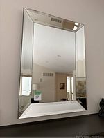 Full view of beveled wall mirror showing rectangular shape and beveled edges.
