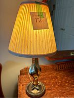 Full view of brass lamp with shade lit, showing lamp height and shade style.