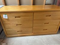 Front view of light wood dresser showing six drawers arranged in two columns with recessed handles.