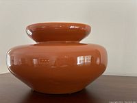 Full side view of the brown ceramic jug showing rounded shape and flared mouth.