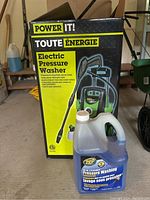 Photo showing Power It electric pressure washer box and a bottle of Zep pressure washing concentrate placed in front.