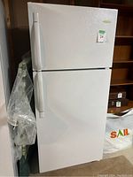 Front view of white top freezer refrigerator with curved vertical handles.