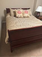 Full view of assembled queen bed frame with bedding for scale